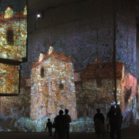 licht en beeldshow, publik wandelt in kalksteengroeve door projecties van werk van en over grote kunstenaars. 